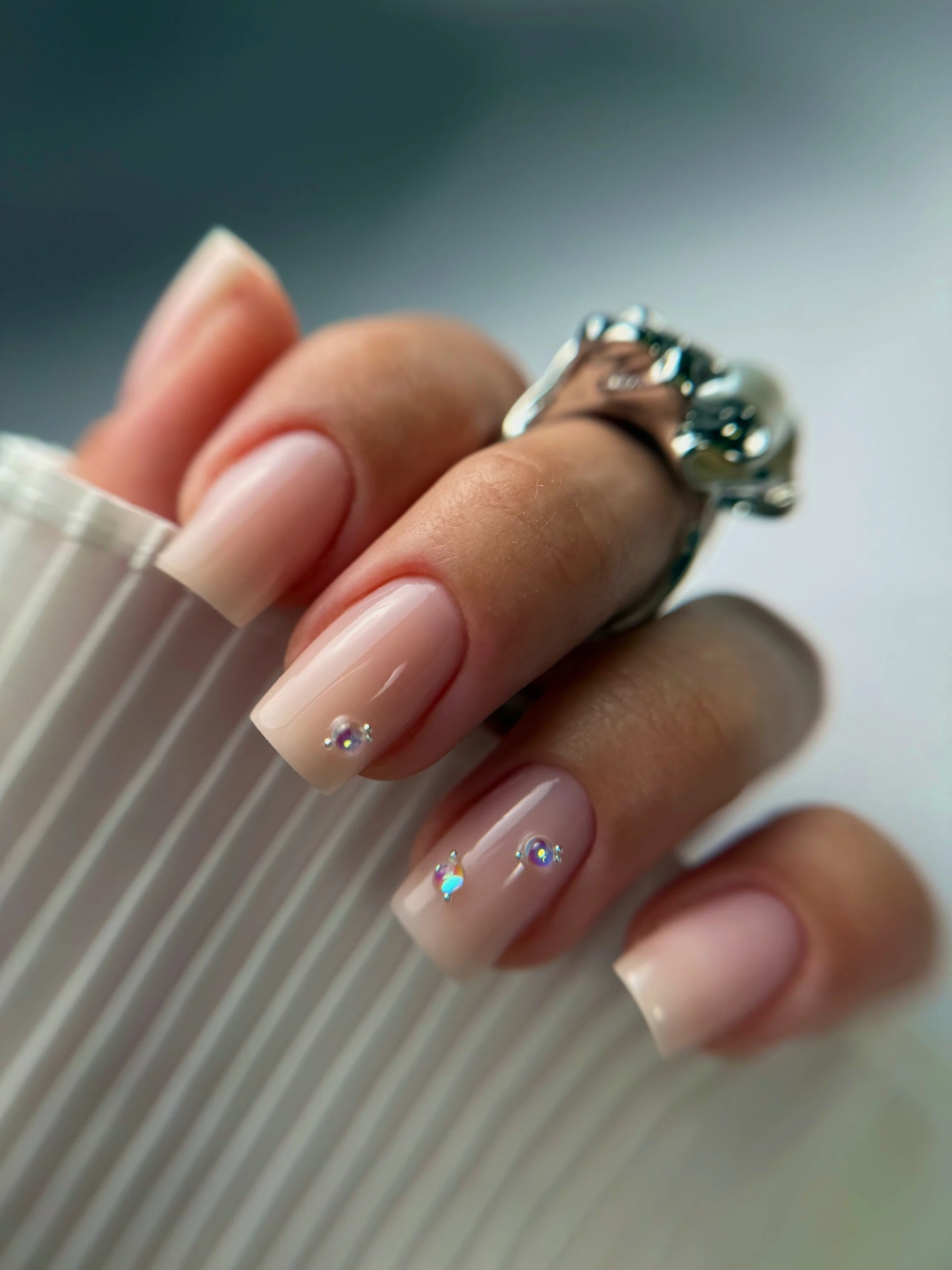 Ongles carrés nude, petites pierres posées sur deux ongles
