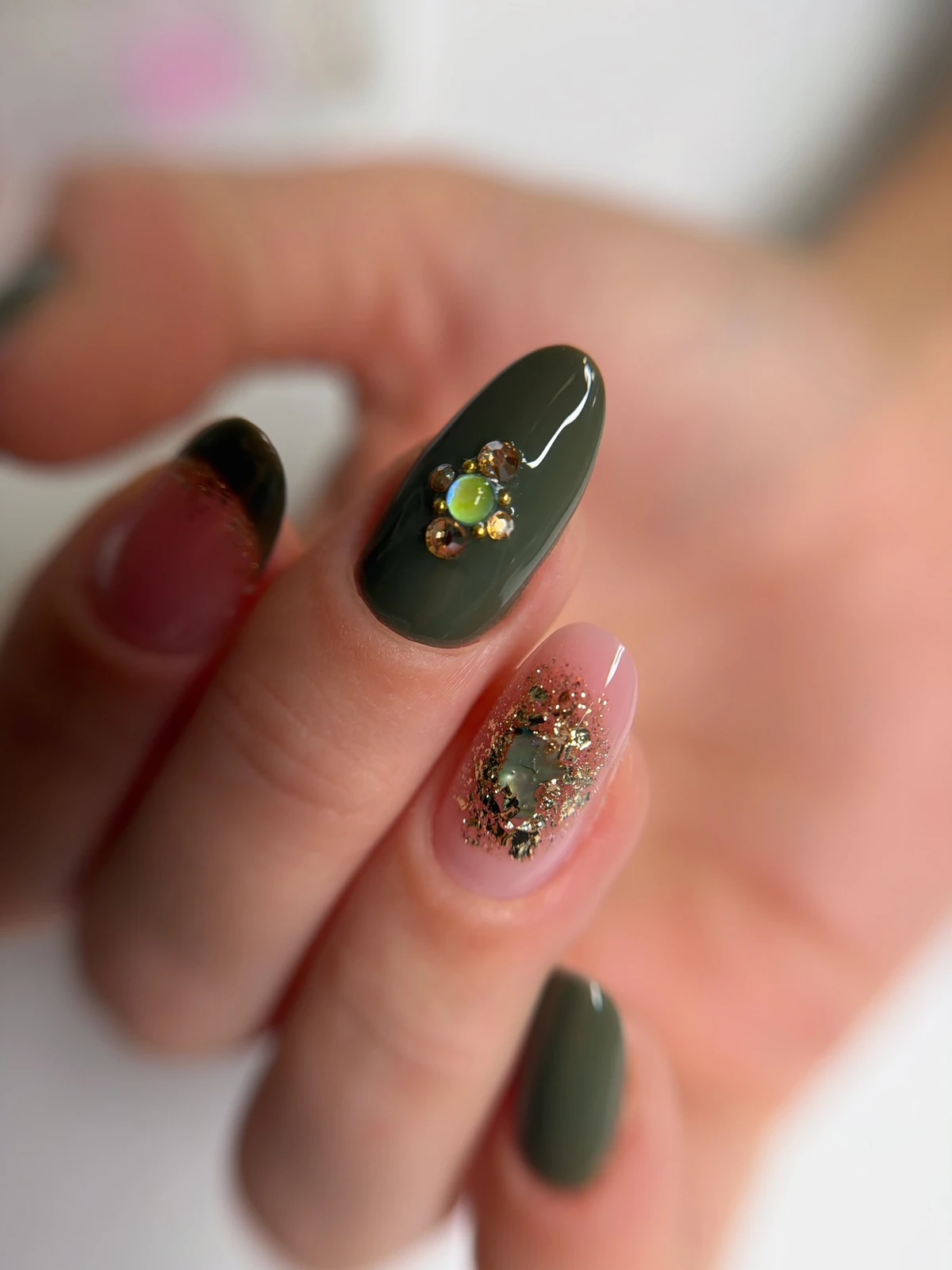 Ongle kaki orné d’un bijou, ongle nude pailleté or